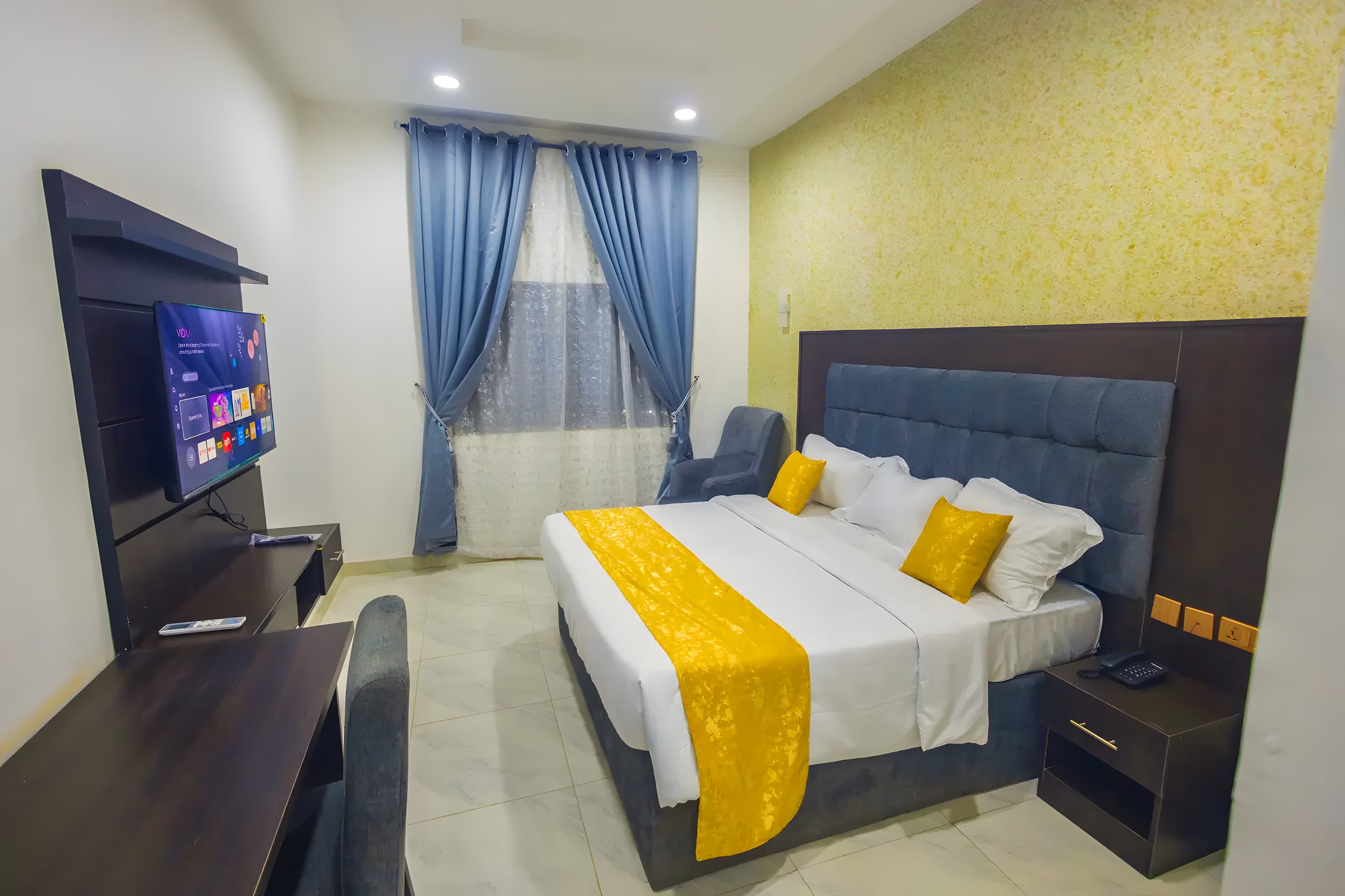 Deluxe Room at Diplomat Enclave Suites with a king bed and premium bedding
