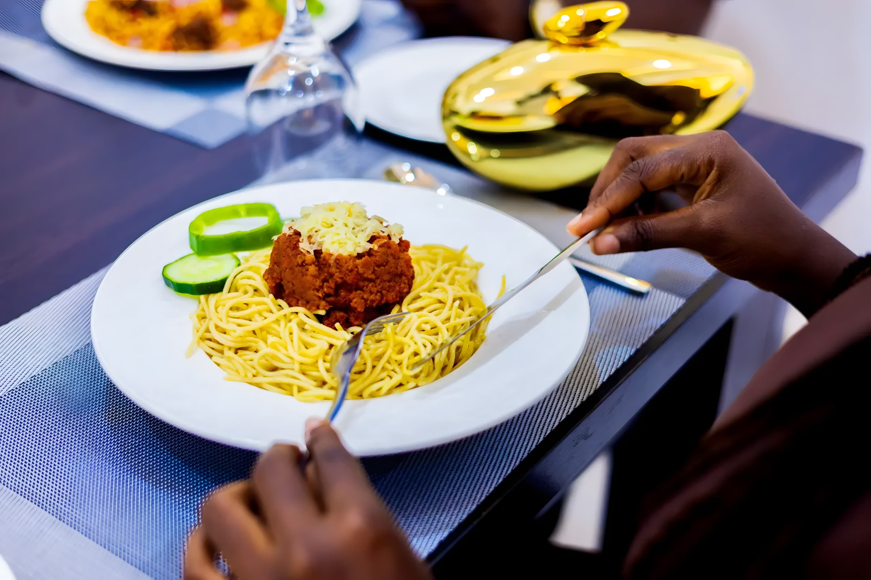 Guest enjoying a freshly served spaghetti meal at Diplomat Enclave Suites restaurant in Abuja