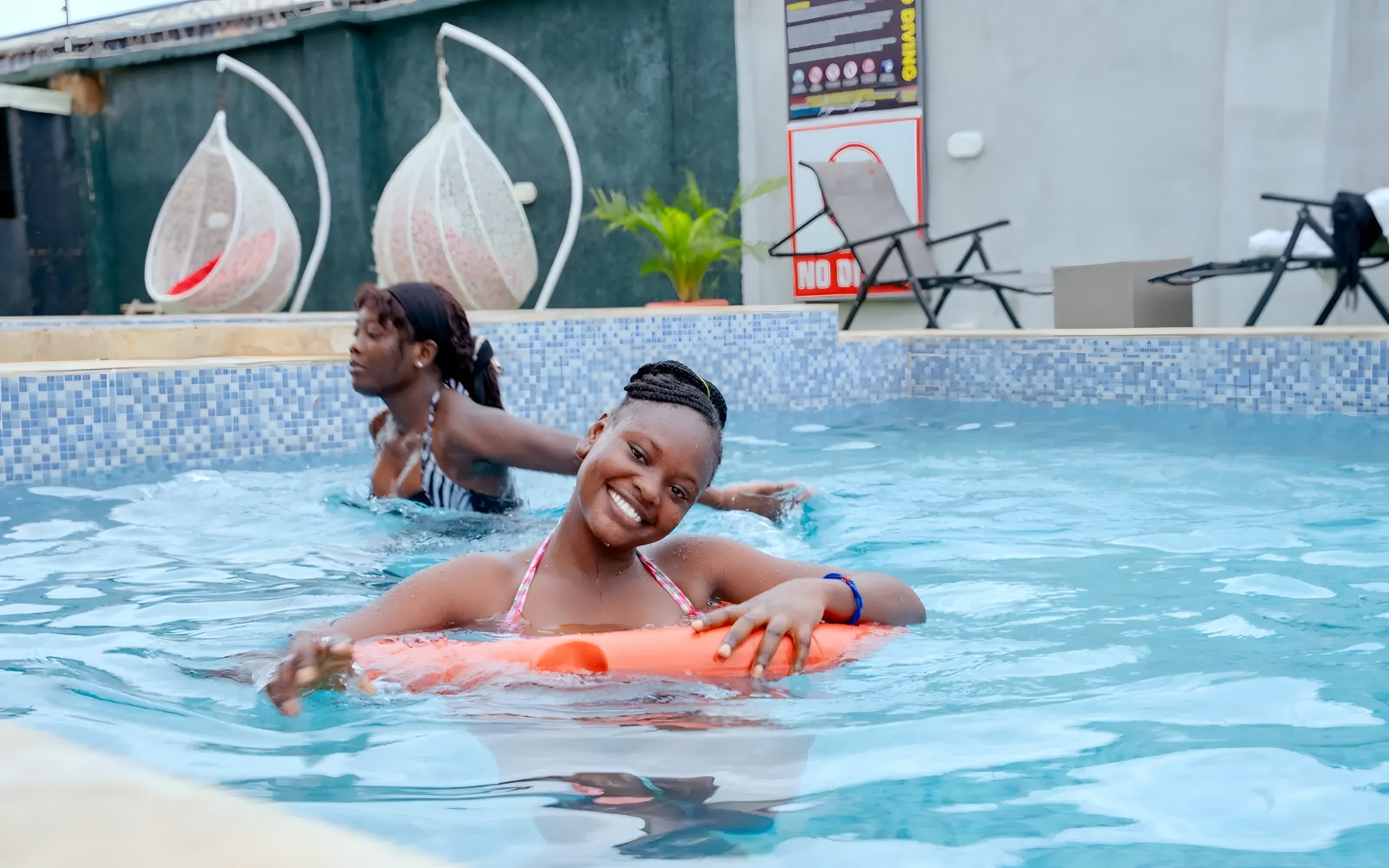 Guests enjoying the outdoor swimming pool at Diplomat Enclave Suites Abuja